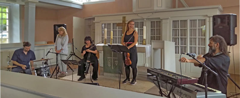 Weltmusik aus Chile in der Kirche Eichenberg. Barbara Freeman (hell gekleidet) vom Gemeindevorstand begrüßt das SUBHIRA-Quartett. Von rechts: SUBHIRA Rodrigo Cepeda, Petra Onderuf, Javier Cienfuegos, Pau Zañartu